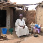 Business woman Asara Azindow in front of her hut